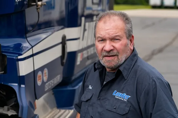 Laufer Trucking driver Raul standing next to his semi-truck in Hartford, Wisconsin.