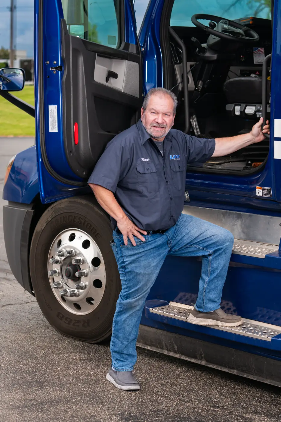 A Laufer Trucking local driver beside a tractor-trailer at the Hartford, Wisconsin yard.